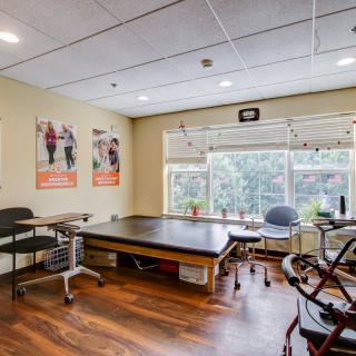 A physical therapy clinic with a treatment table and exercise equipment.