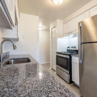 A modern kitchen with granite countertops and stainless steel appliances.