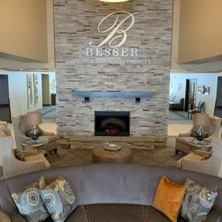 A modern lobby with a central fireplace and comfortable seating.