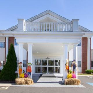 The entrance of a building decorated with autumn-themed decorations and white columns.