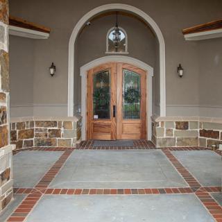 Elegant front entrance with wooden double doors and arched design.