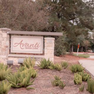 Entrance sign surrounded by landscaping and greenery.