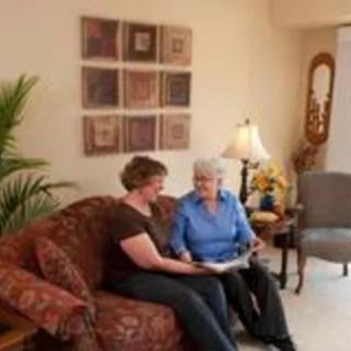 Two people sitting on a sofa having a conversation in a cozy living room.