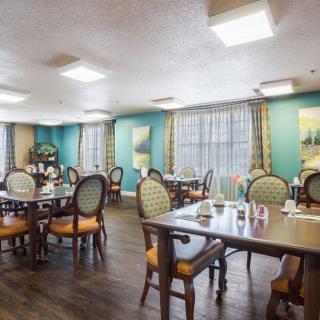 A cozy dining room with neatly arranged tables and chairs, featuring elegant decor.