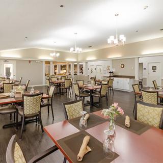 A spacious dining room with neatly arranged tables and chairs, enhanced by soft lighting.
