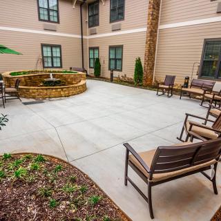 A spacious courtyard with outdoor seating and a central fireplace.