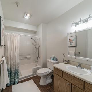 A modern bathroom interior with a shower, sink, toilet, and mirror.