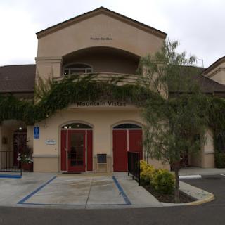 A view of a charming two-story building with inviting entrances and lush landscaping.