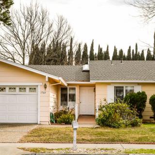 A suburban house with a driveway and a garage, surrounded by trees.