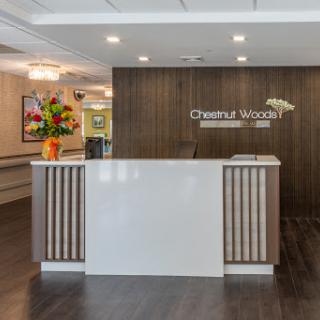 A modern reception area featuring a sleek desk and vibrant floral arrangements.