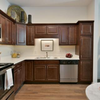 A modern kitchen with wooden cabinets and stainless steel appliances.
