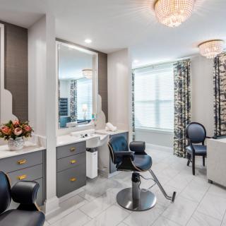 A modern hair salon interior with stylish chairs, mirrors, and elegant lighting.