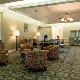 A cozy lobby with patterned chairs, elegant lighting, and a spacious seating arrangement.