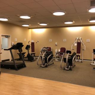 A well-equipped gym room with various exercise machines.