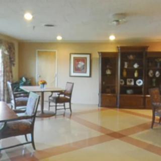 A well-furnished room with chairs, tables, and a decorative cabinet.