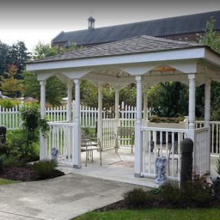 A charming white gazebo surrounded by lush greenery, perfect for outdoor gatherings and relaxation.