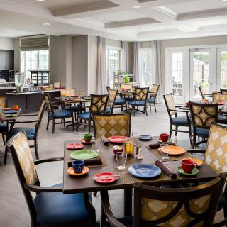 A spacious dining room with neatly arranged tables and colorful place settings.