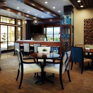 A modern restaurant dining area with stylish tables and chairs, featuring large windows and elegant interior design.