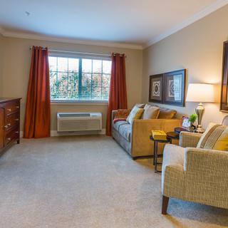 A cozy living room with a sofa, armchair, and warm lighting.