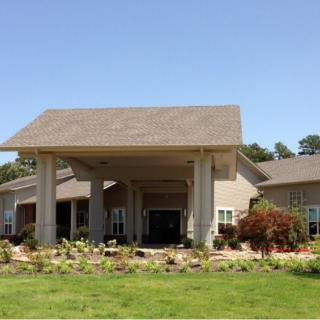 A modern building with a prominent entrance and landscaped surroundings.