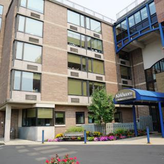 A modern multi-story building featuring large windows and an inviting entrance.