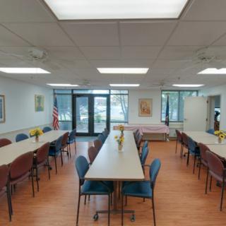 A well-lit meeting room with long tables and chairs arranged for a conference.