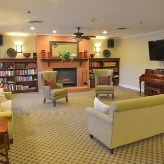 A cozy living room with comfortable seating, a fireplace, and bookshelves.