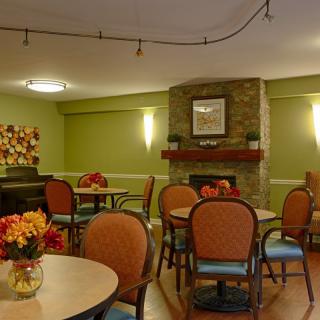 Cozy dining area with tables, chairs, and a fireplace.