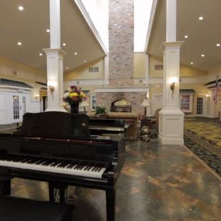 A luxurious lobby featuring a grand piano with high ceilings and elegant architectural details.