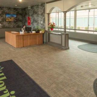 A hotel lobby with a reception desk and large windows.