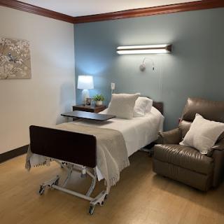A well-equipped hospital room with a patient bed, a comfortable chair, and soothing decor.