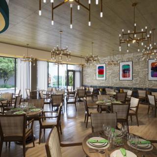 A modern restaurant dining area with elegant chandeliers, contemporary artwork, and neatly arranged tables and chairs.