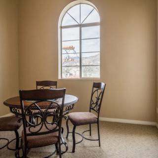 A cozy dining area with an arched window and a round table.