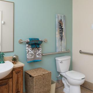 A clean and tidy bathroom featuring a toilet, sink, and stylish decor.