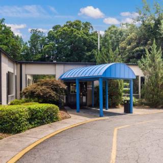 A welcoming entrance featuring a blue canopy and surrounded by lush greenery.
