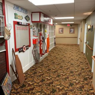A hallway adorned with vintage and nostalgic decor, featuring retro signs and a patterned carpet.