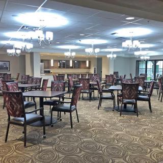 A spacious and well-lit dining area with elegant furniture, designed for communal meals.