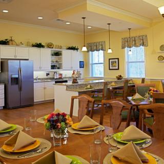 A modern kitchen and dining area featuring elegant table settings, contemporary appliances, and warm lighting.