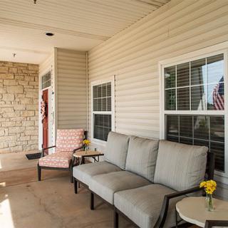 A cozy patio area with seating and a small side table adorned with flowers.