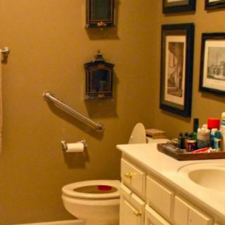 A neatly decorated bathroom with wall art and a well-organized countertop.
