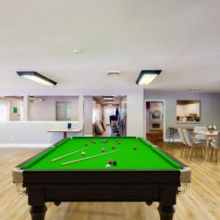 A vibrant pool table set in a spacious game room, perfect for recreation and social gatherings.