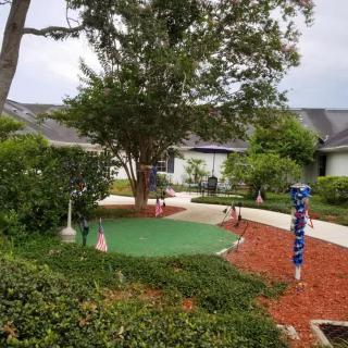 A scenic garden area featuring a mini golf course with surrounding pathways and trees.