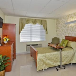 A well-appointed hospital room with a bed, TV, and medical equipment.