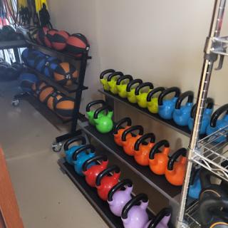 A well-organized display of colorful kettlebells in a gym setting, ready for workouts.