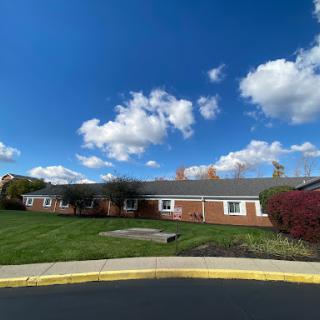 A charming residential building set against a bright blue sky with fluffy clouds.