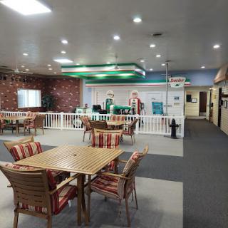 A spacious dining area with wooden tables and chairs, featuring a welcoming atmosphere.