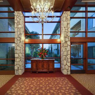 Elegant lobby with stone walls and a chandelier.