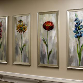 A series of vibrant floral paintings elegantly framed on a wall, enhancing the interior decor.