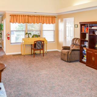 A cozy living room with a workspace and comfortable seating.
