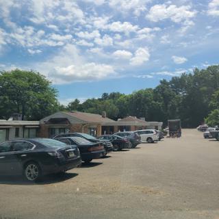 A view of a parking lot filled with various cars under a partly cloudy sky.